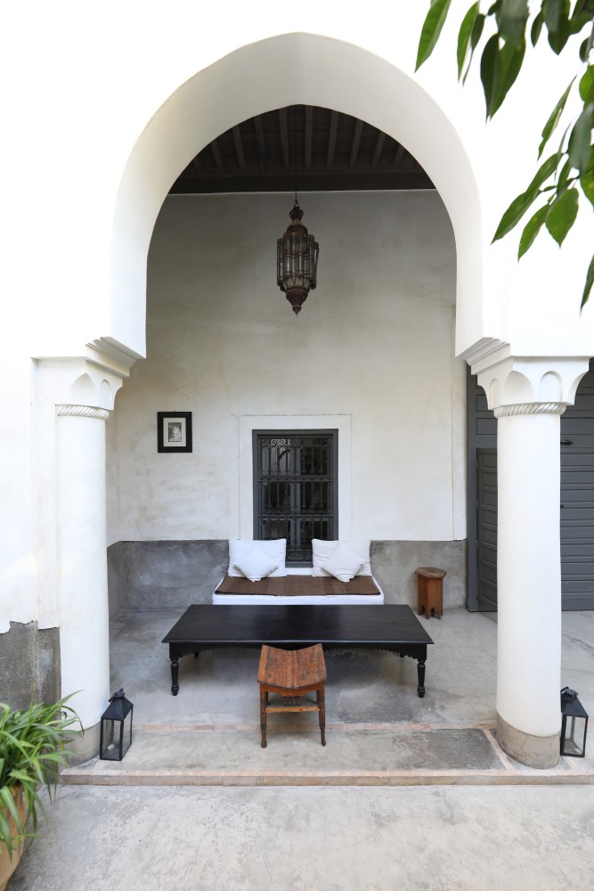 Le bhou du jardin — banquette sous l'arche, lanterne allumée