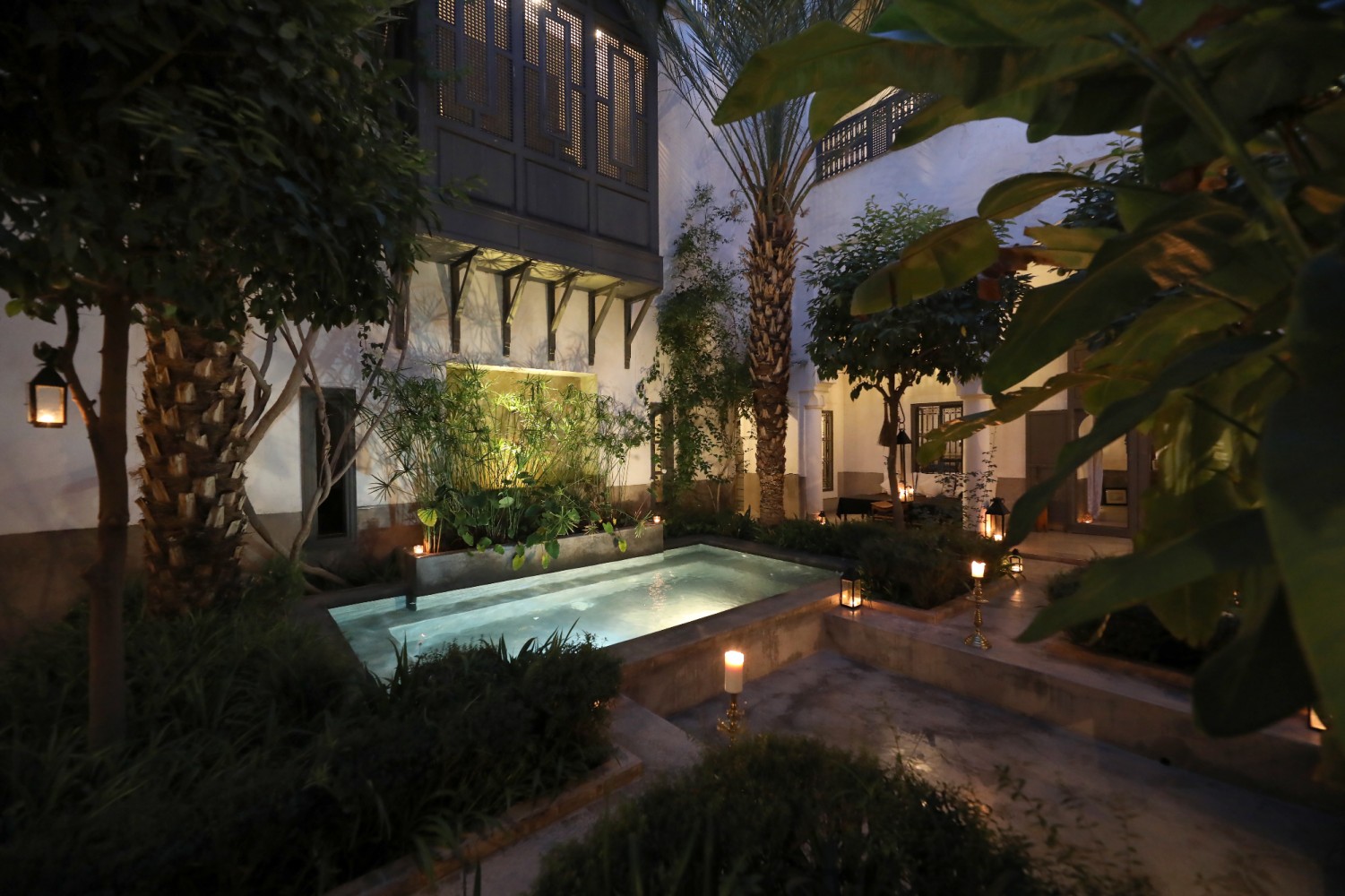 Le patio-jardin du Riad Zaouia 44 à la nuit tombée, bougies et lanternes autour du bassin