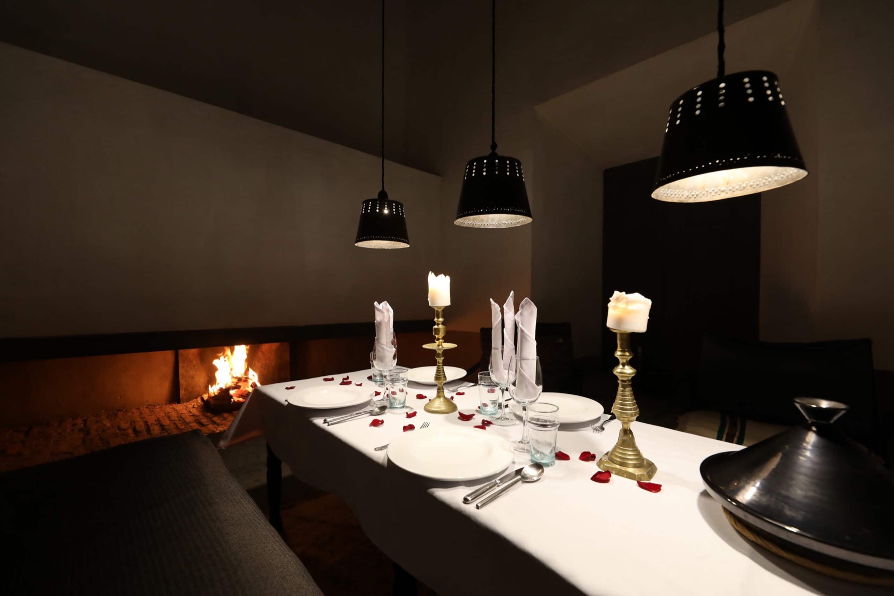 La table d'hôtes dressée aux chandelles, devant la cheminée du salon